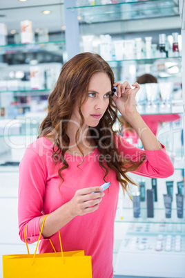 Pretty woman trying a mascara