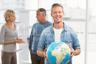 Smiling businessman holding terrestrial globe