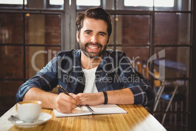 Young man taking notes in his notebook