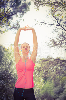 Blonde athlete stretching arms with eyes closed