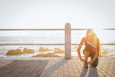Fit woman tying her shoelace at promenade