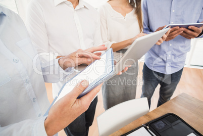 Business people using several electronic devices