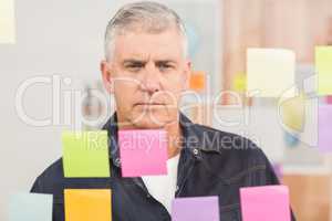 Casual businessman looking at a post it wall