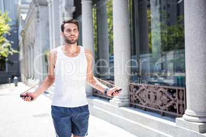 Handsome athlete skipping with jump rope