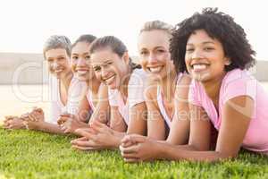 Smiling women lying in a row and wearing pink for breast cancer