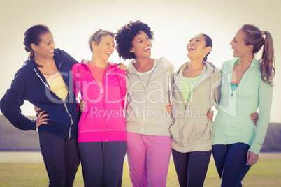 Laughing sporty women with arms around each other