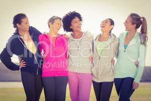 Laughing sporty women with arms around each other