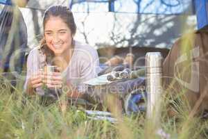 Smiling brunette camper lying in tent