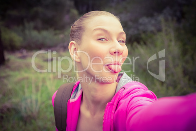 Smiling female hiker taking a funny selfie