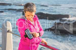 Sporty woman listening to music via headphones
