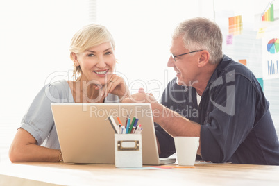 Smiling business team working on laptop