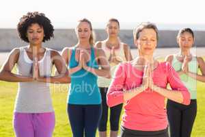 Peaceful sporty women doing prayer position in yoga class