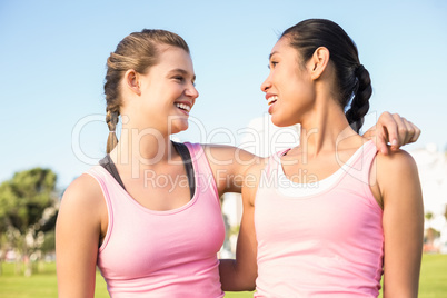 Two smiling women wearing pink for breast cancer