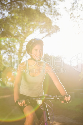 Smiling athletic brunette mountain biking