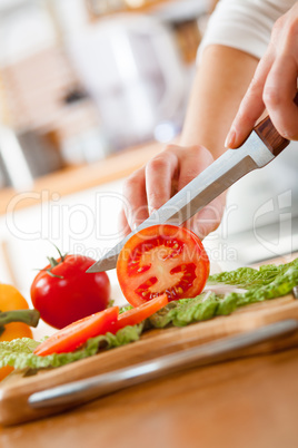Woman's hands cutting tomato