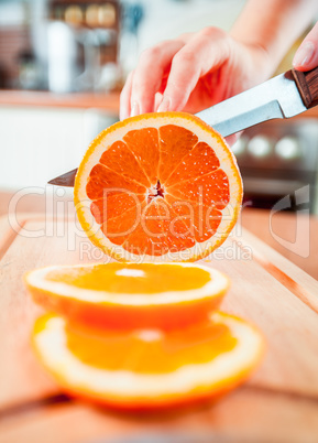 Woman's hands cutting orange