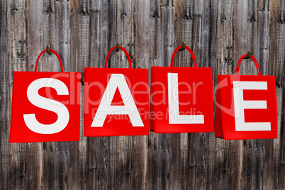 Four shopping bags with the word SALE Hanging on the wall