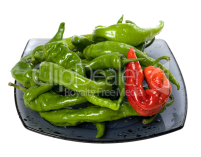Green and red chili peppers on glass plate