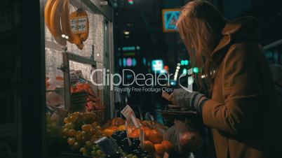 Young woman buys products in the stall outside