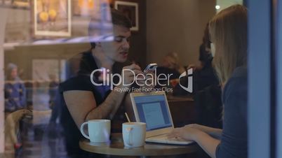 Man and woman work in the restaurant using gadgets
