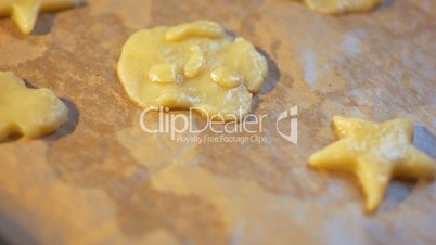 Woman puts pastry dough molds on the paper