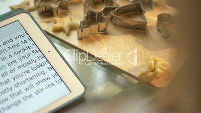 Woman reads recipe and makes molds for pastry dough