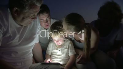 Big Family Watching Bedtime Story on Tablet PC