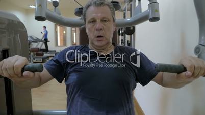 Sweaty man working out on exercise machine