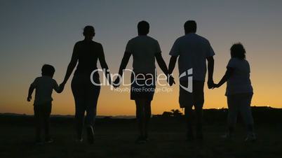 Big friendly family walking outdoor at sunset
