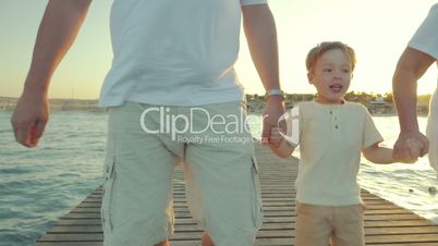 Grandparents with grandchild on the pier at sunset