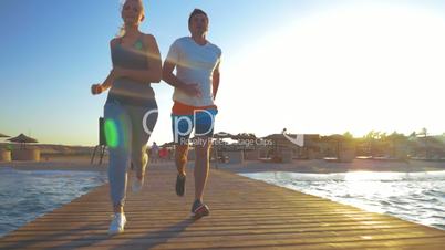 Couple Jogging on the Sea Pier