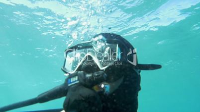 Scuba diver in blue water on sunny day