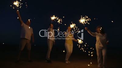 Family with sparklers on the beach at night