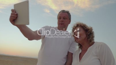 Senior couple using touch pad outdoor on vacation