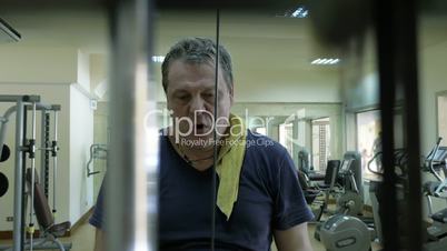 Mature man working out on pulldown machine