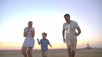 Parents having happy time with child on the beach