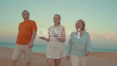 Young woman and parents walking on beach