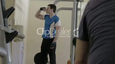 Man drinking water during break in the gym