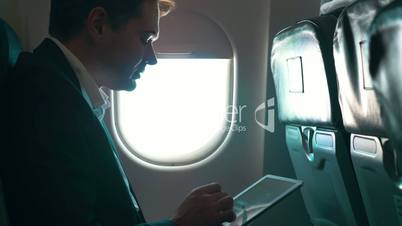 Man using tablet computer during the flight