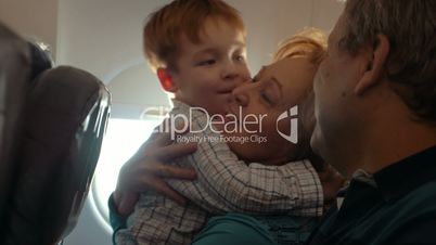 Boy and his grandmother hugging in the plane