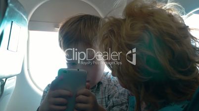 Grandmother and grandson with cell in the plane