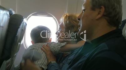 Grandparents and little grandson traveling by plane
