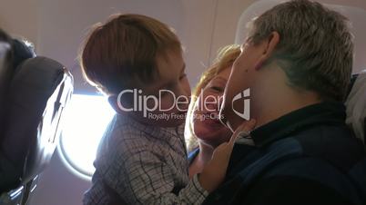 Child exploring grandfathers face in the plane