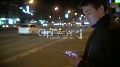 Man using touch pad by the busy road in city