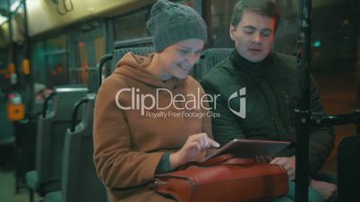 Young people using tablet computer in the bus