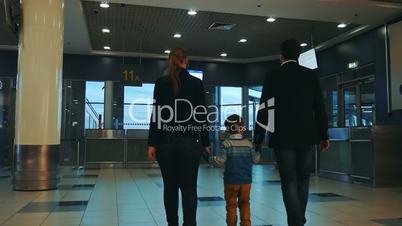 Family of three walking in airport terminal