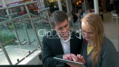 Couple with Tablet PC on Escalator