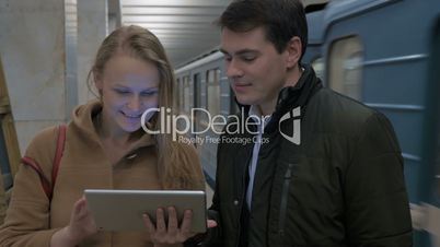 Young people with tablet computer in subway