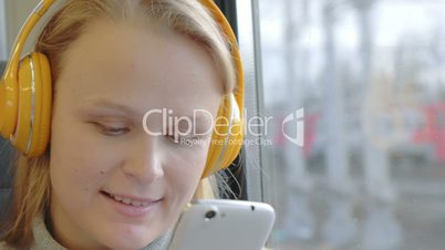 Woman using cell and listening to music in the train