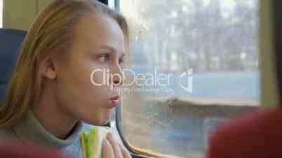 Woman having snack while traveling by train